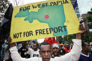 A Papuan protester with a poster of a map of Papua province during a demonstration outside the office of Freeport-McMoRan's Indonesian subsidiary, Jakarta, March 1, 2006, AP photo by Dita Alangkara.